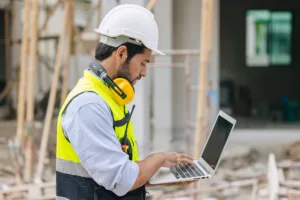 operaio in cantiere con un pc portatile