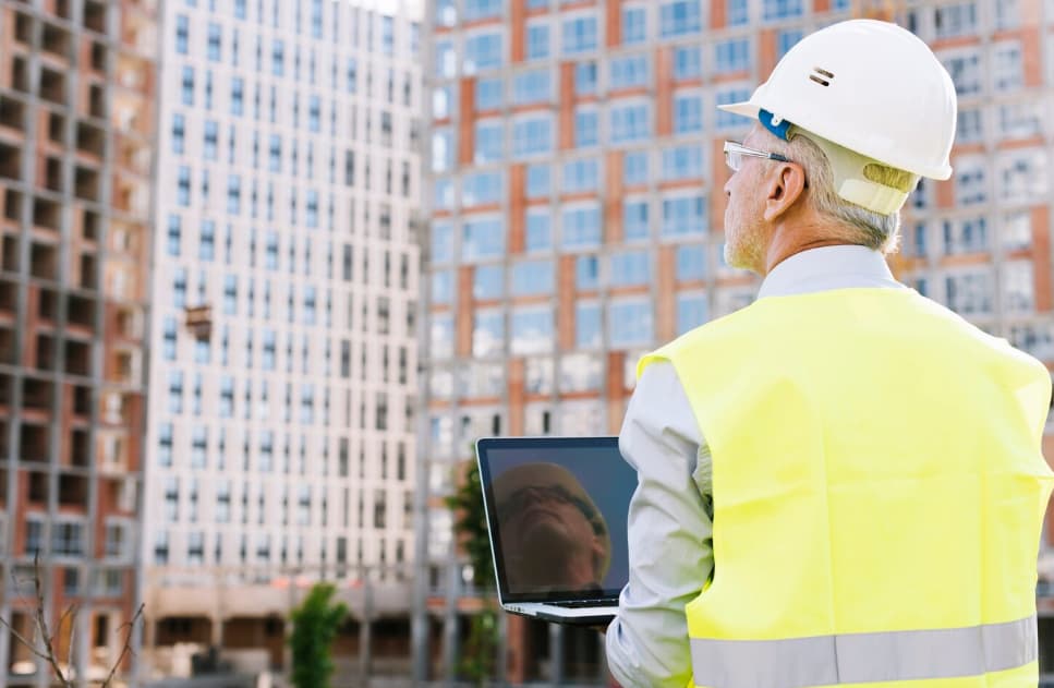 controllo dei cantieri edili. Signore con pettorina gialla che controlla con un tablet il progresso dei lavori